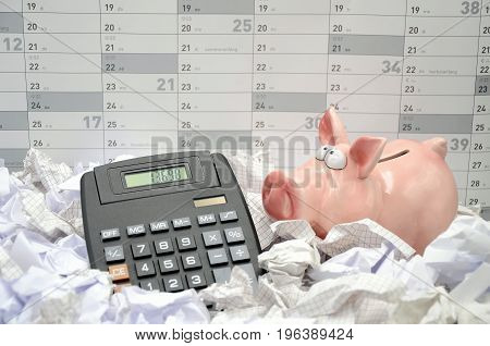 calculater with piggy bank behind a calender