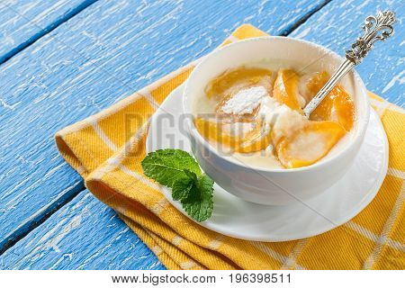 Delicious creamy apricot dessert in white cup on yellow napkin. Summer desserts with fruits. Dietary and healthy food