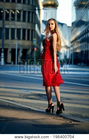 Beautiful blonde lady in red dress on White Square office center in Moscow Russia