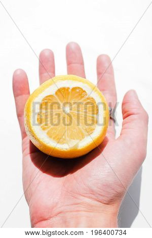 A man holds a slice of lemon for juice