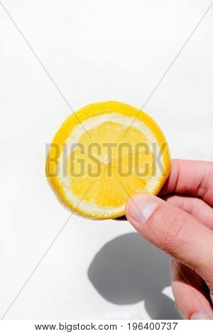 A man holds a slice of lemon for juice