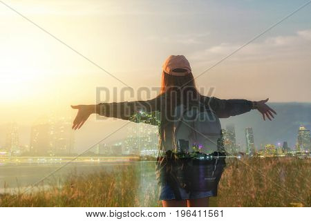Double exposure Freedom traveler woman standing with raised arms and enjoying a beautiful nature and cheering young woman backpacker at sunrise seaside mountain peak