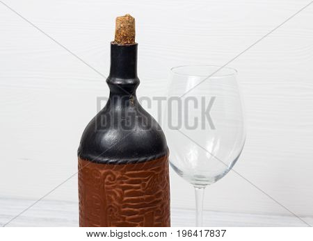 Black bottle of wine and wneglass on the background of the canvas