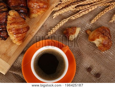 Morning cup of hot coffee and croissant.