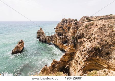 Travel To Stunning Rocks Cliffs With Seas Caves On Sandy Camilo Beach In Colorful Sunny Blue Sky