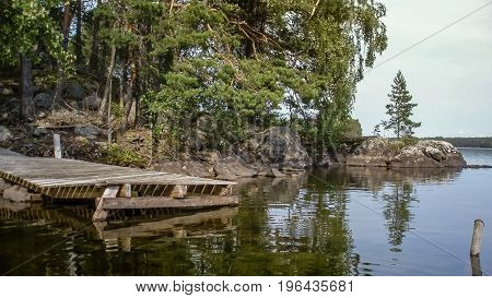 Old wodden pier leading in dark finnish forest