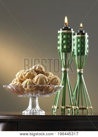 malay tradition food bahulu on the glass plate and oil lamp at the side