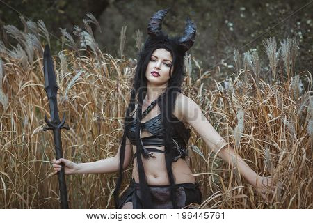 Portrait of a savage girl with horns in the thickets