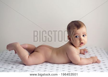 naked child lying on her belly on the diaper with stars