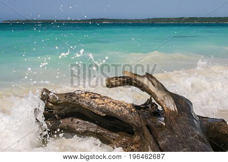 Wave breaking on the beautiful white beach of Baru island
