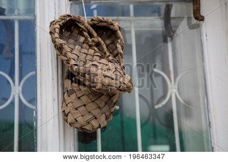 Pair bast shoes close up window background