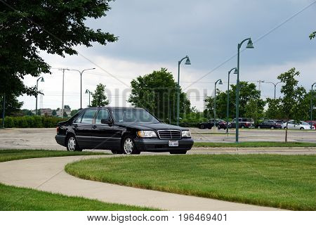 PLAINFIELD, ILLINOIS / UNITED STATES - JUNE 30, 2017: A 1996 black Mercedes-Benz S420 luxury sedan is parked in the parking lot of the Edward Plainfield Outpatient Center.