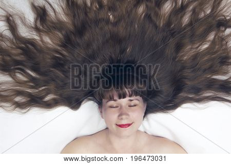slipping beauty with long hair top view on white