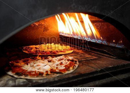 pizza prepares in old stove near fire