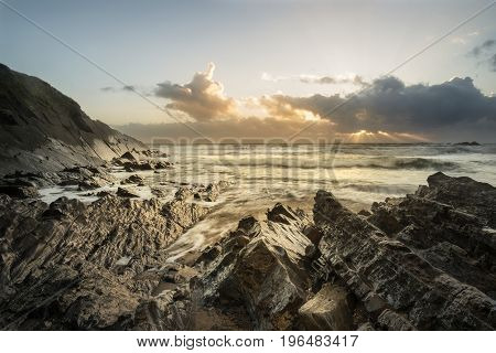 Beautiful Colorful Vibrant Sunset Over Rocky Beach With Long Exposure