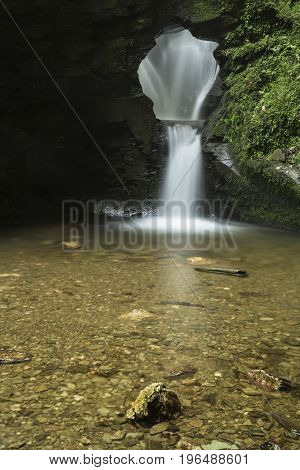 Beautiful Flowing Waterfall With Magical Fairytale Feel In Lush Green Forest Location
