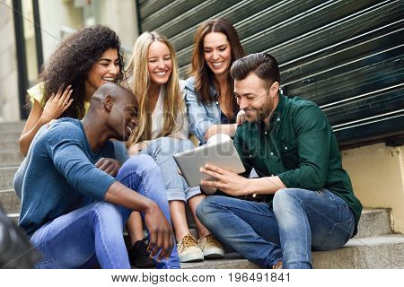 Multi-ethnic Group Of Young People Looking At A Tablet Computer