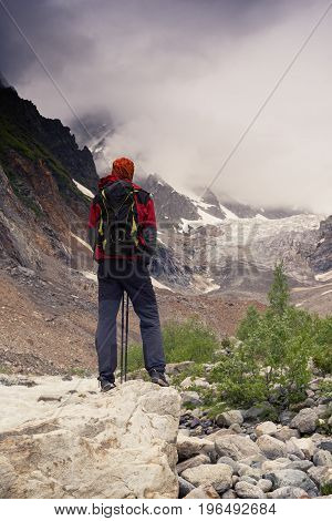 Man Adventurer Looks At The Glacier Lying In Front Of Him
