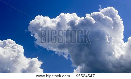 a big and fluffy cumulonimbus cloud in the blue sky.