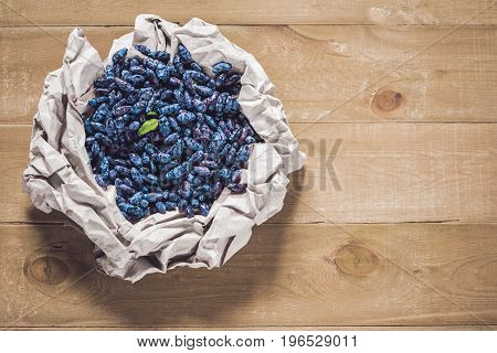 Fresh Honeysuckle Blue Berry Fruits With Leaf On A Wooden Background
