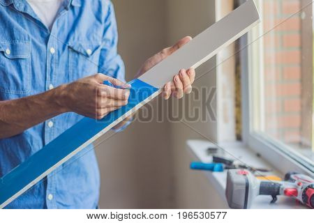 Man In A Blue Shirt Does Window Installation