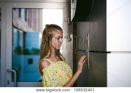 Woman Dials An Apartment Code On An Electronic Doorphone Panel