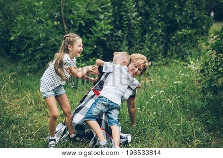 Grandmother playing in the park with grandchildren, siter with brother