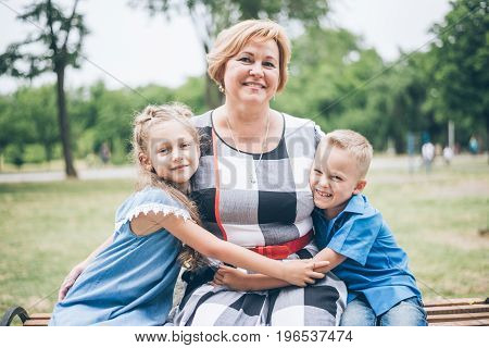 Grandmother playing in the park with grandchildren, siter with brother