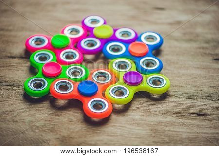 Colored Fidget Spinners Stress Relieving Toy On Wooden Background