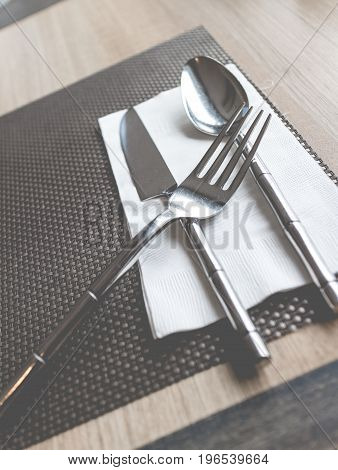 Plates and cutlery on a wooden table. Cutlery set of fork spoon and knife in vintage theme