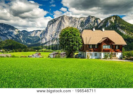 Amazing summer landscape with green fields alpine farmland pasture and high rocky mountains in background Altaussee Salzkammergut Austria Europe