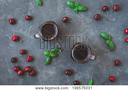 Cherry juice and fresh cherries on black background. Top view flat lay