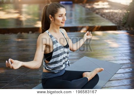 Meditating is a smart idea. Girl practicing yoga in the beggining of her workday away from technology.