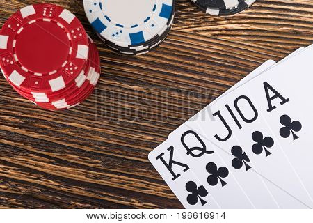 set of winning poker cards on a wooden table with poker chips