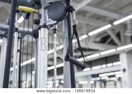 Closeup picture of hanging handle machine in a gym for pulling training.