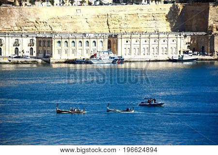VALLETTA, MALTA - MARCH 31, 2017 - Passengers on board a traditional Maltese Dghajsa water taxi in the grand harbour with views towards Valletta Vittoriosa Malta Europe, March 31, 2017.