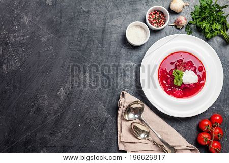 Homemade Russian, Ukrainian and Polish national soup - red borscht made of beetrot, vegetables and meat with sour cream Top view.