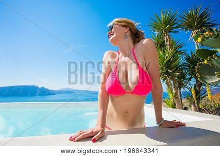 Sexy woman with big boobs getting out of pool