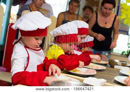 Alchevsk, Ukraine - July 23, 2017: School Cook For Children. Meat Rolls With Cheese Are Prepared.