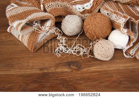 Balls of wool and knitting on the wooden background