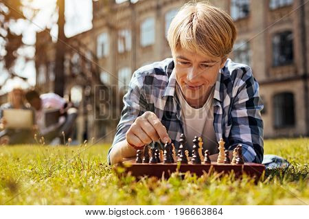 Calculating the moves. Lively motivated productive guy training his cognitive abilities by developing game strategy