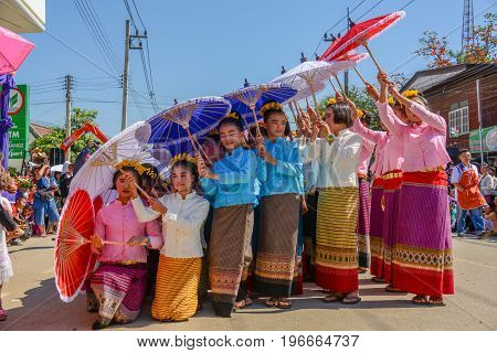 CHIANGMAI THAILAND - JANUARY 25 2015: Indigenous little girls with traditional costume holding umbrellas and dancing in traditional style in parade of 22nd Traditional Skirt Fabric and The Indigenous Product and Culture Festival in Mae Chaem Chiangmai Tha