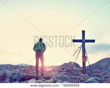 Alone Man Climber Near The Summit Cross On Peak, Dolomite Alps, Austria. Sunny Windy Evening.