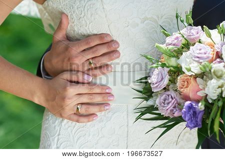groom embraces the brides waist on a wedding walk.