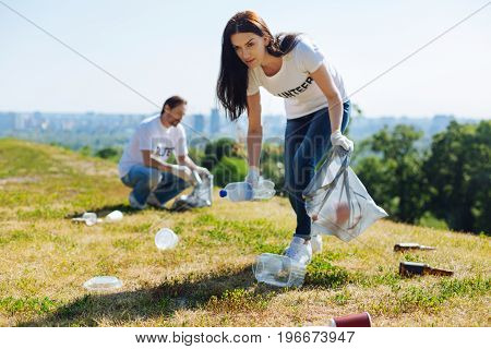 Eco enthusiast. Young motivated intelligent lady working as a volunteer and participating in environmental initiative while collecting litter in the park