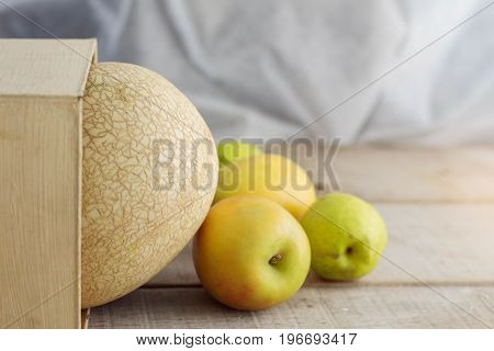 Melon and apple on old wood flooring.