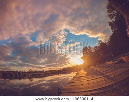 Landscape water river lake mooring surface reflecting mirror sky at sunset dawn. Wide angle action camera go pro.