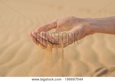 Desert, Sand Puffs Through The Fingers Of A Man's Hand