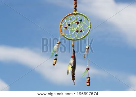 Dream catcher in the wind against the sky
