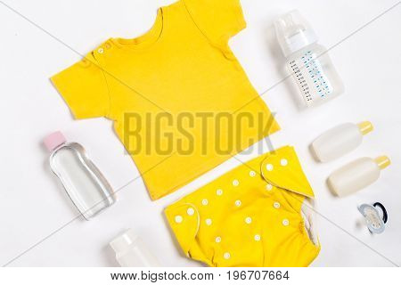 Baby clothes and accessories on white background. Top view. Copy space. Still life. Flat lay
